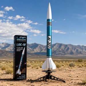 LOC-IV 4-inch high-power model rocket standing on a launch pad in a desert landscape with mountains in the background under a blue sky