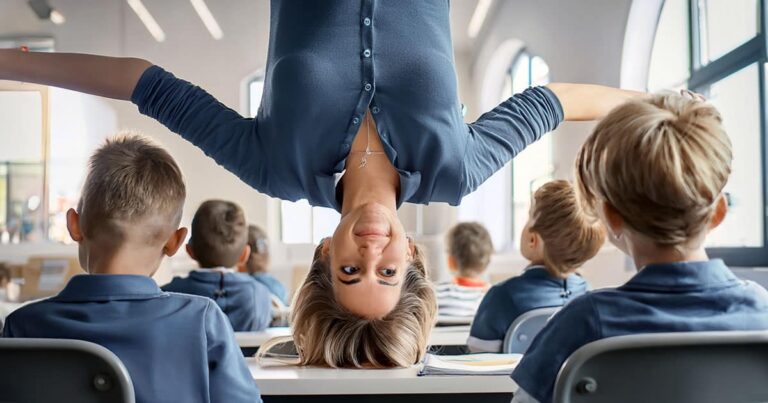 Teacher doing handstand on desk